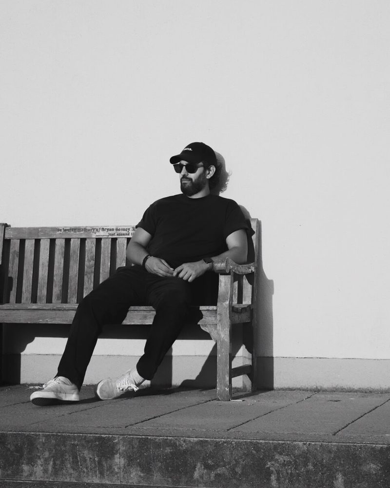 Jonny (Mitekiss) sitting on a bench, black and white